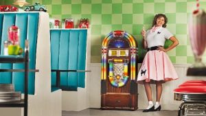 Jeanne Stangel in a poodle skirt poses by a 1950s jukebox in Yesteryear Village